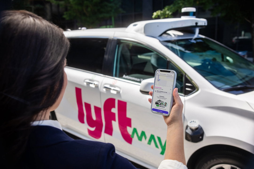 TechDogs-"An Image Of A Rider Using The Lyft App To Hail A Robotaxi"